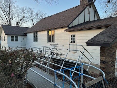 A white house with a wheelchair ramp in front of it.