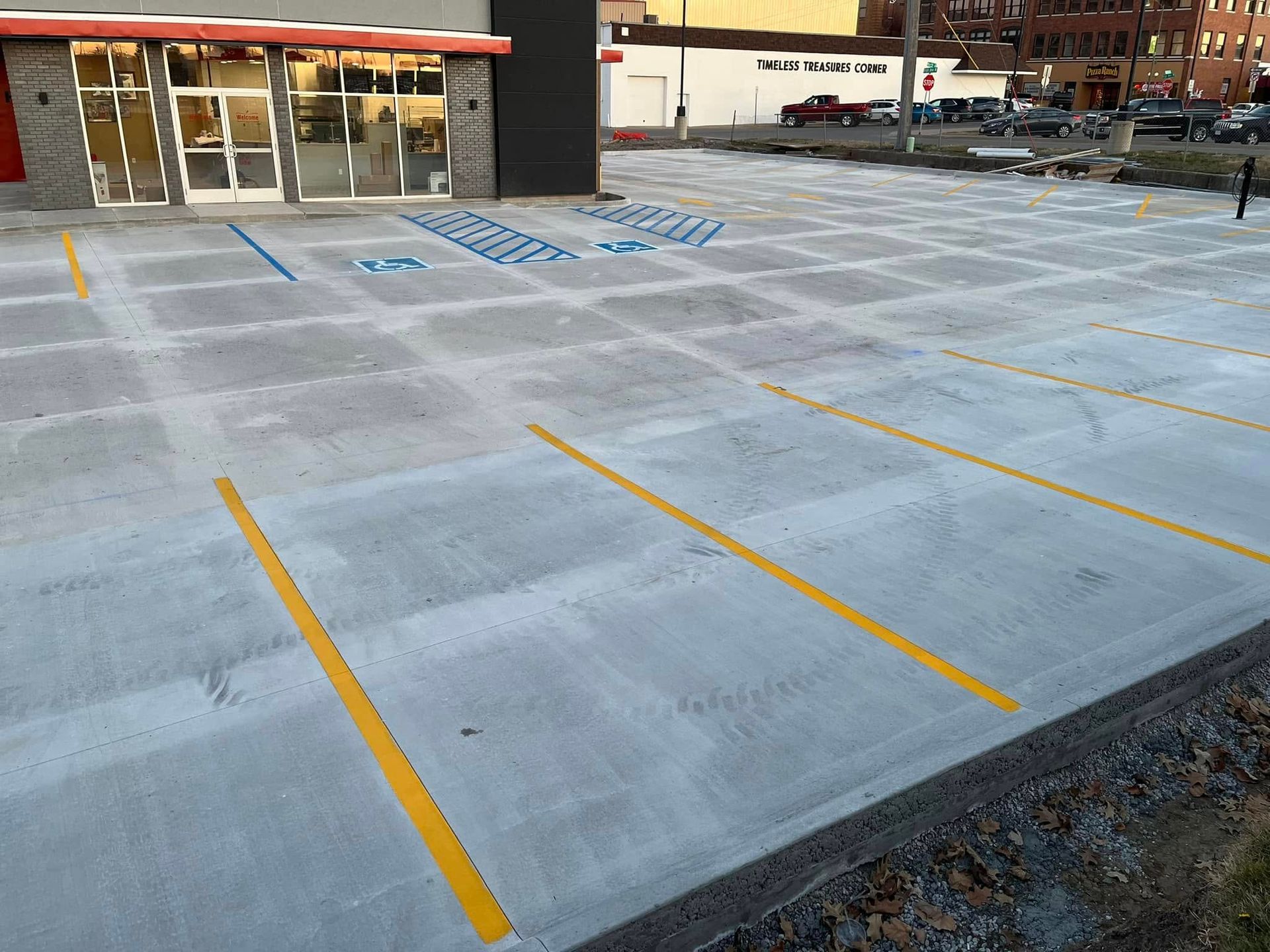 Empty accessible parking spaces with blue markings outside a storefront