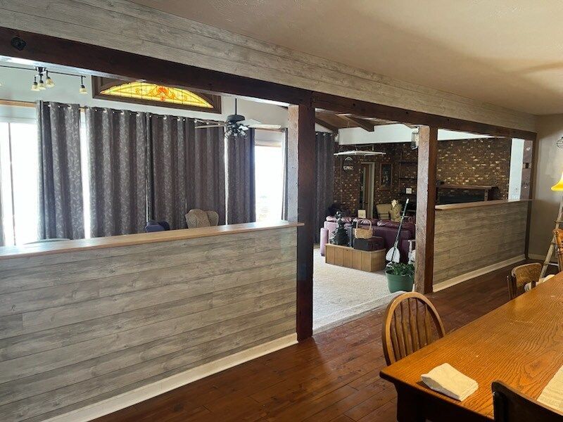 A living room with a table and chairs and a stained glass window.