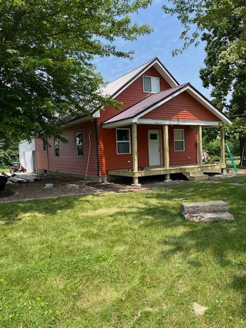 A red house with a porch and a white door