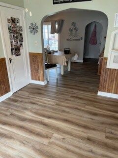 A living room with hardwood floors and a table and chairs.