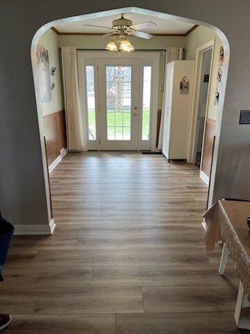 A living room with hardwood floors and a ceiling fan.