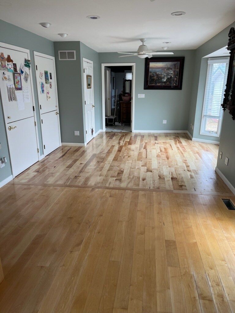 A living room with hardwood floors and a ceiling fan.