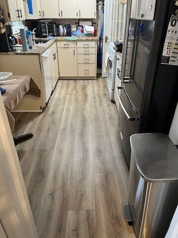 A kitchen with hardwood floors and stainless steel appliances.