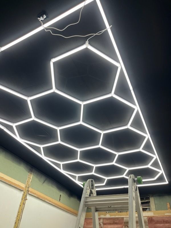 A ladder is sitting under a ceiling with a honeycomb design.