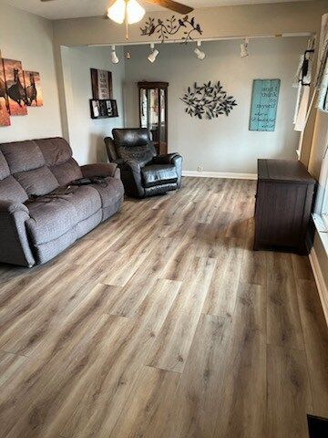 A living room with a couch , chair , and dresser.