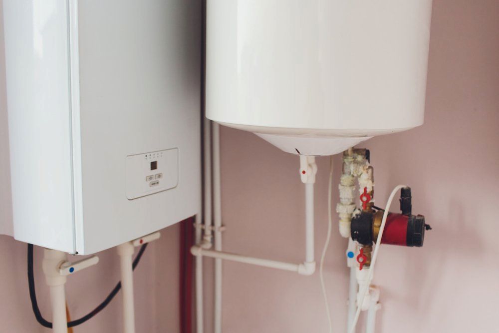 Two Water Heaters Are Sitting Next to Each Other in a Room — SOS Hot Water & Plumbing Services in Kiama Downs, NSW
