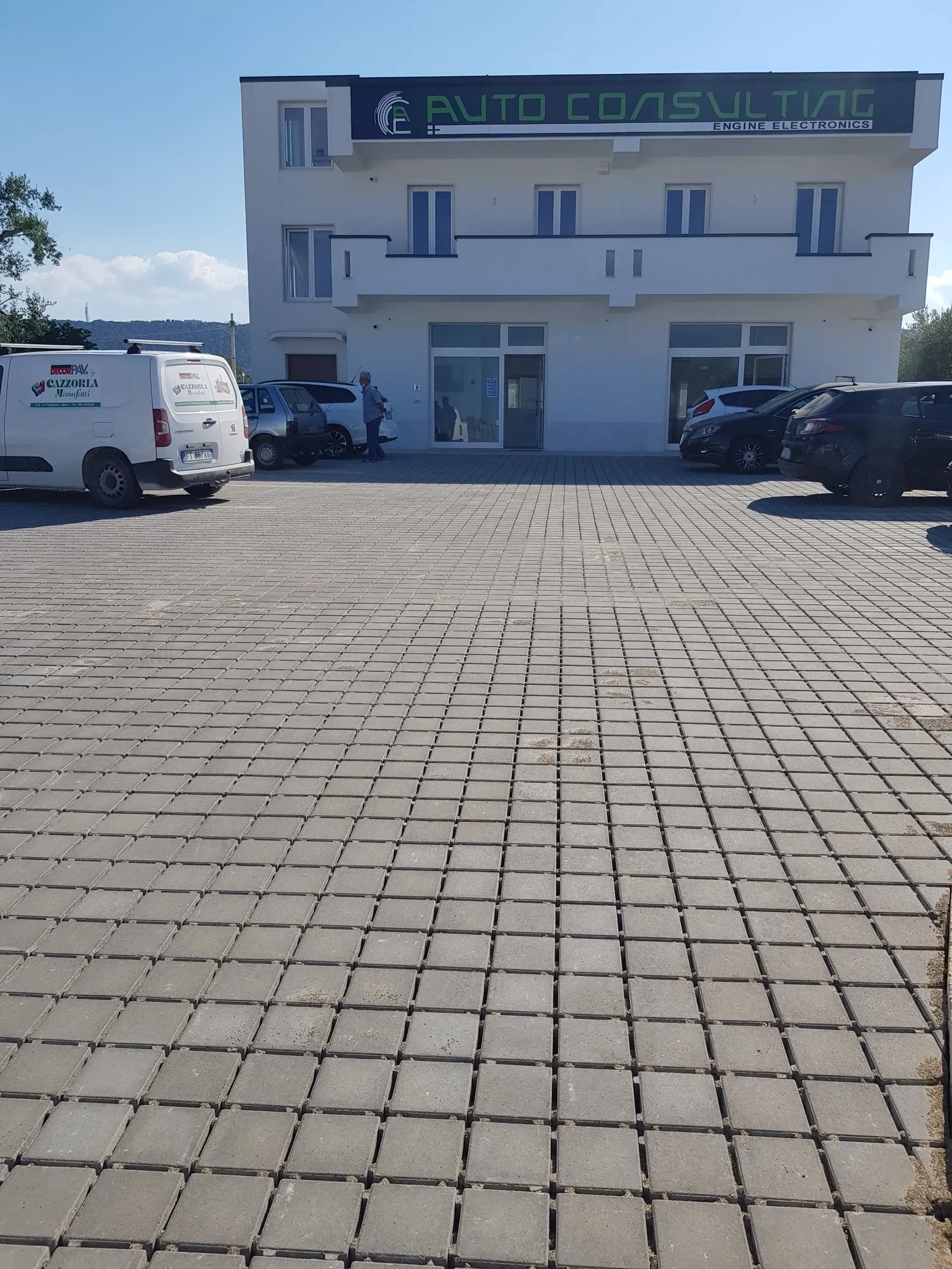Vista esterna di un edificio bianco di tre piani con l'insegna 