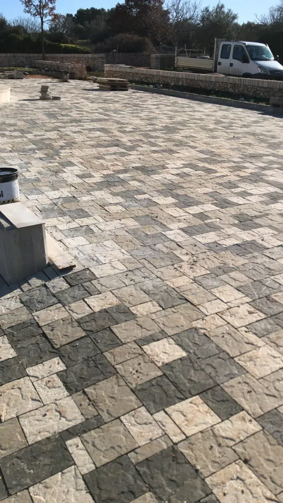 Pavimentazioni in pietra posate a griglia. Le pavimentazioni sono disponibili in varie tonalità di grigio e beige.