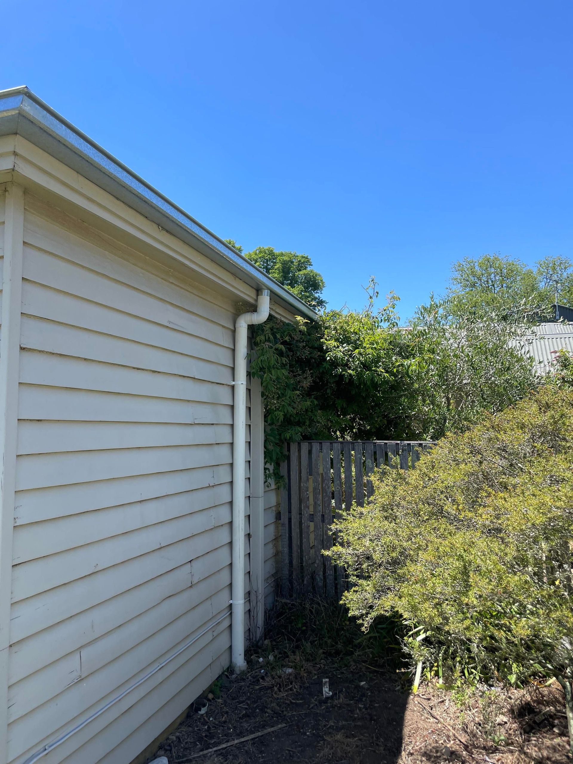 The Side Of A House With Trees And Blue Sky — iFix Roofing Geelong In South Geelong, VIC