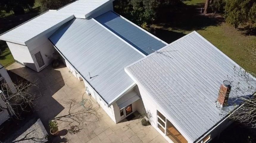 Aerial View Of A White House With A Metal Roof And A Small Chimney — iFix Roofing Geelong In South Geelong, VIC
