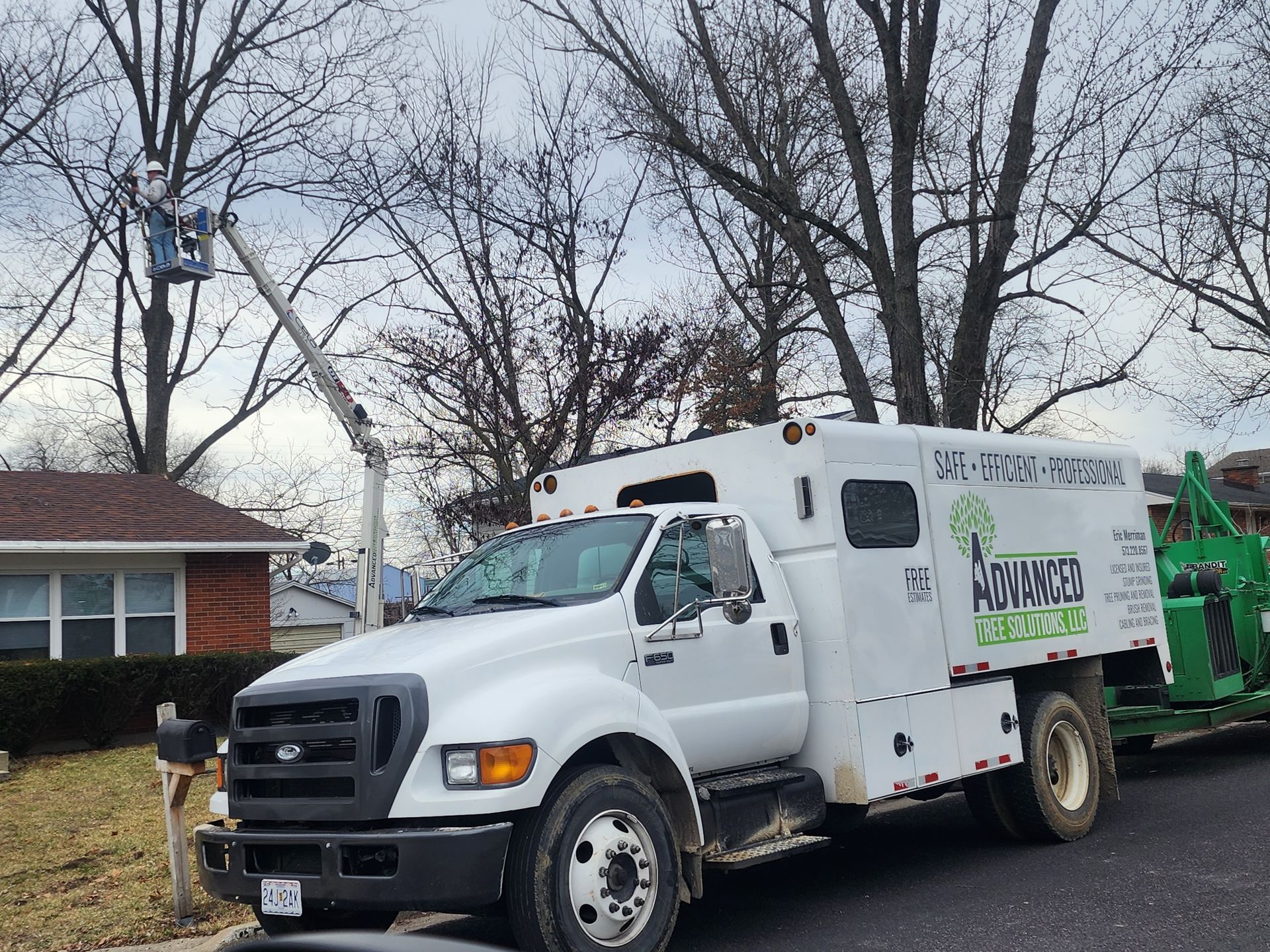 An Advanced Tree Solutions LLC truck is parked in front of a house.