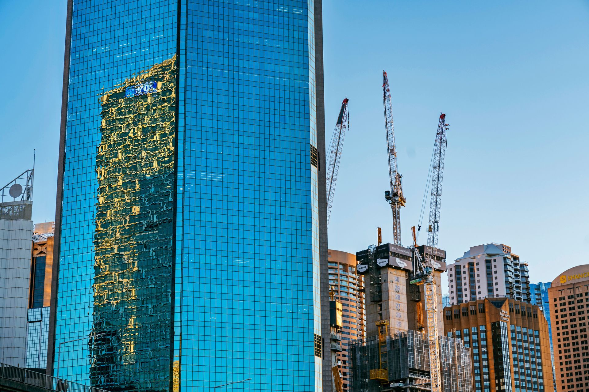 A tall building with a lot of windows is under construction in a city.