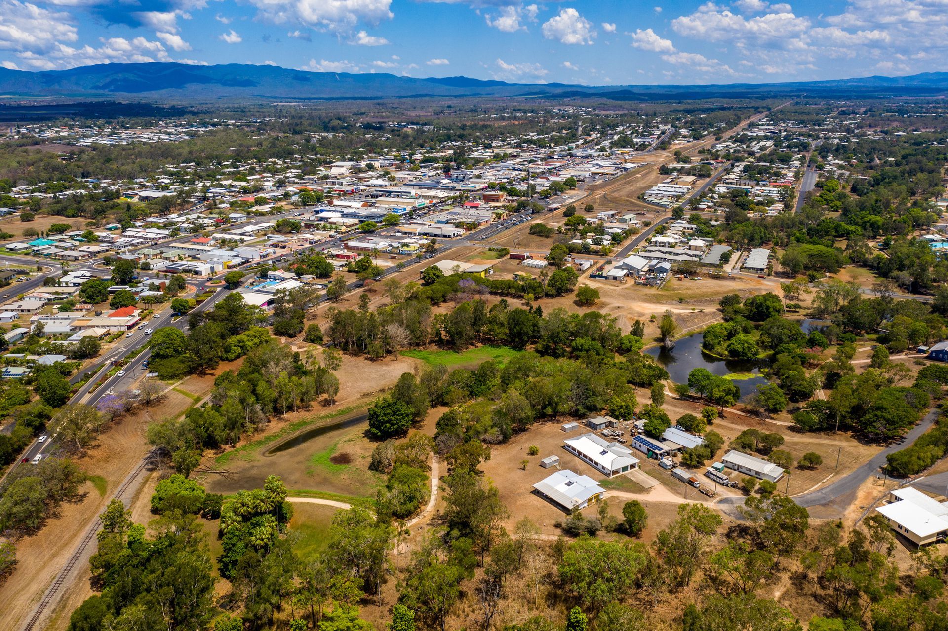 An aerial view of a small town surrounded by trees and houses.