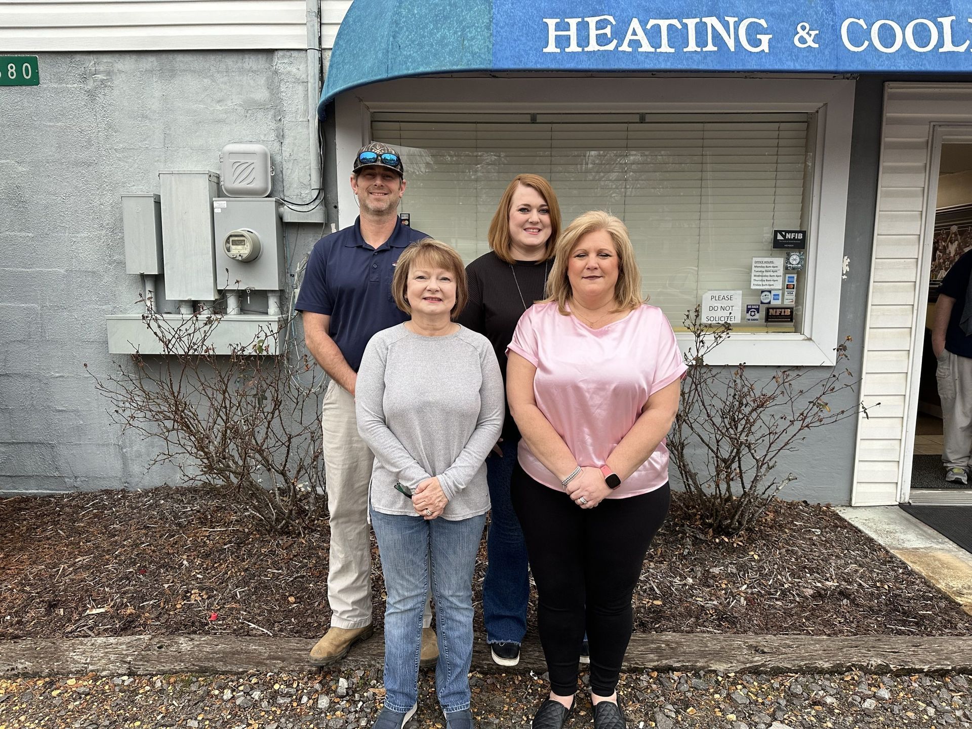 Four people stand outside a building with 
