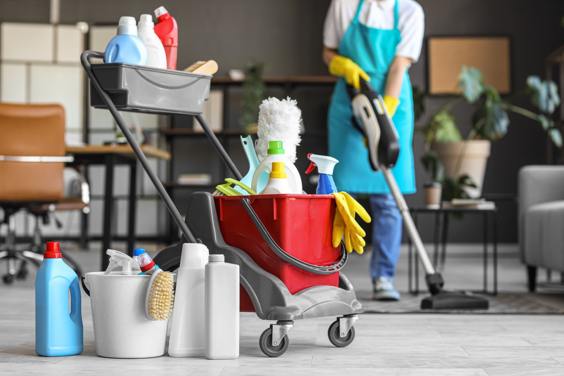 A woman is cleaning a living room with a vacuum cleaner.