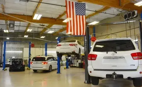 Hondas and Toyotas in an automotive shop with American flag