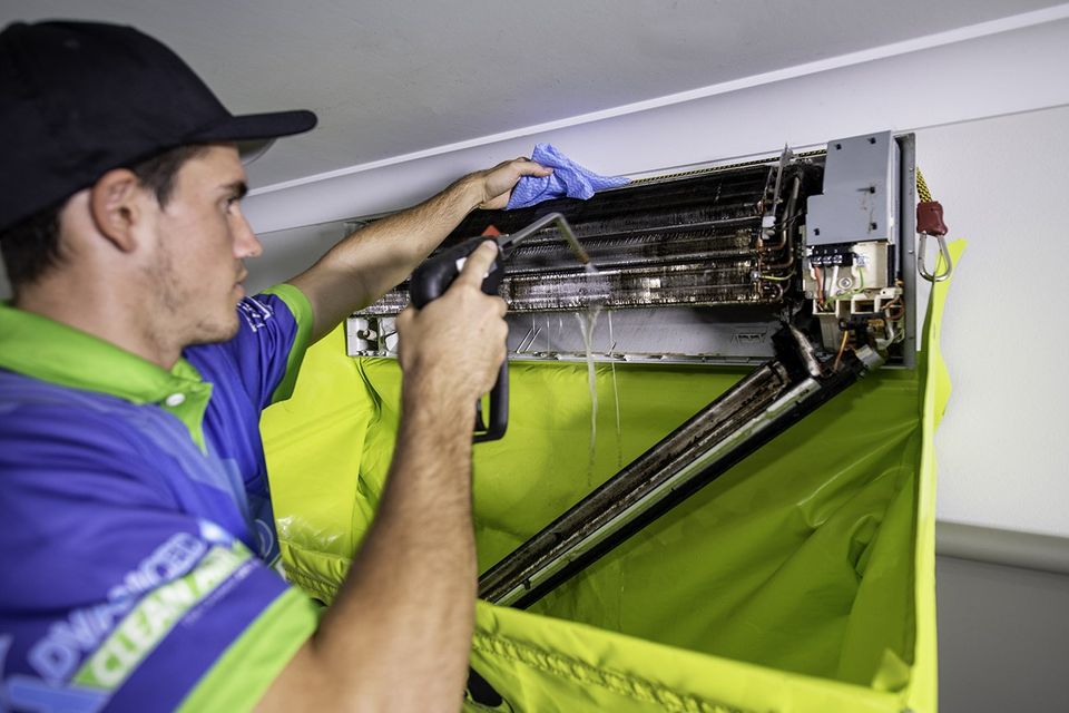 Technician cleaning an air conditioner in Darwin