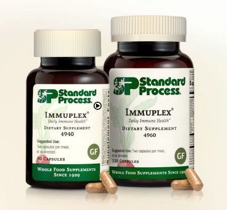 Two brown bottles of Standard Process Immuplex dietary supplement with capsules scattered.