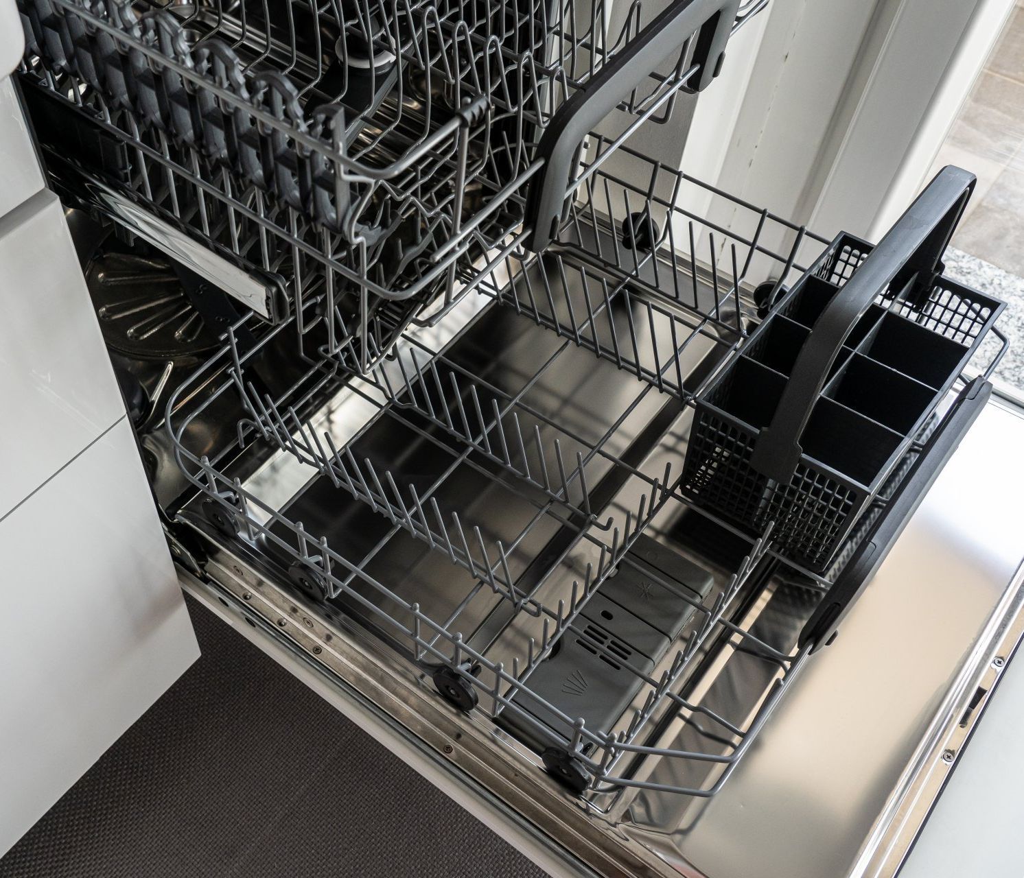 An open dishwasher with clean and empty racks, ready to be filled with dishes.