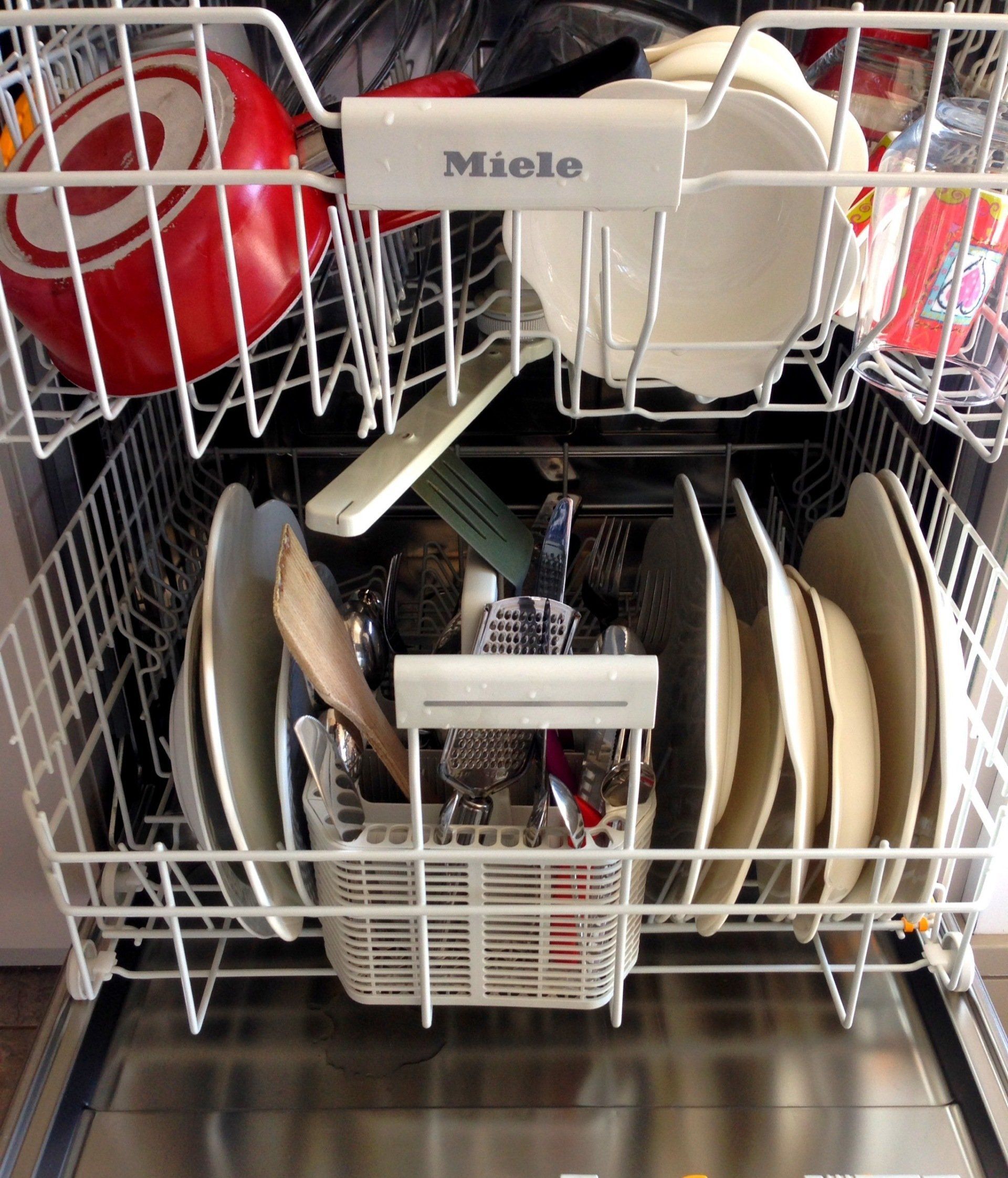 A dishwasher filled with sparkling clean dishes arranged neatly in rows, ready to be put away.
