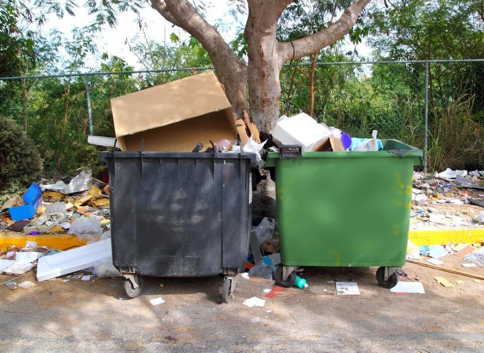 A man is repairing a refrigerator in a kitchen.