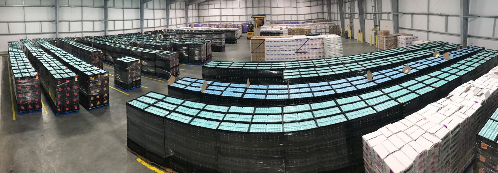 Warehouse interior filled with neatly stacked crates and cartons of eggs, organized in rows for storage and distribution.
