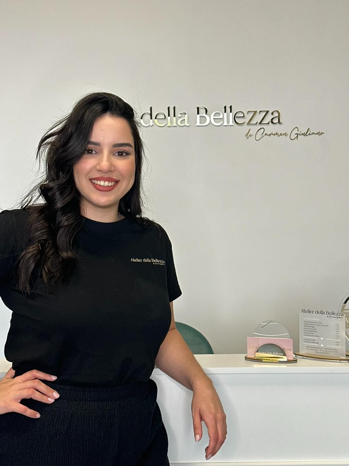 A woman in a black shirt is standing in front of a counter.