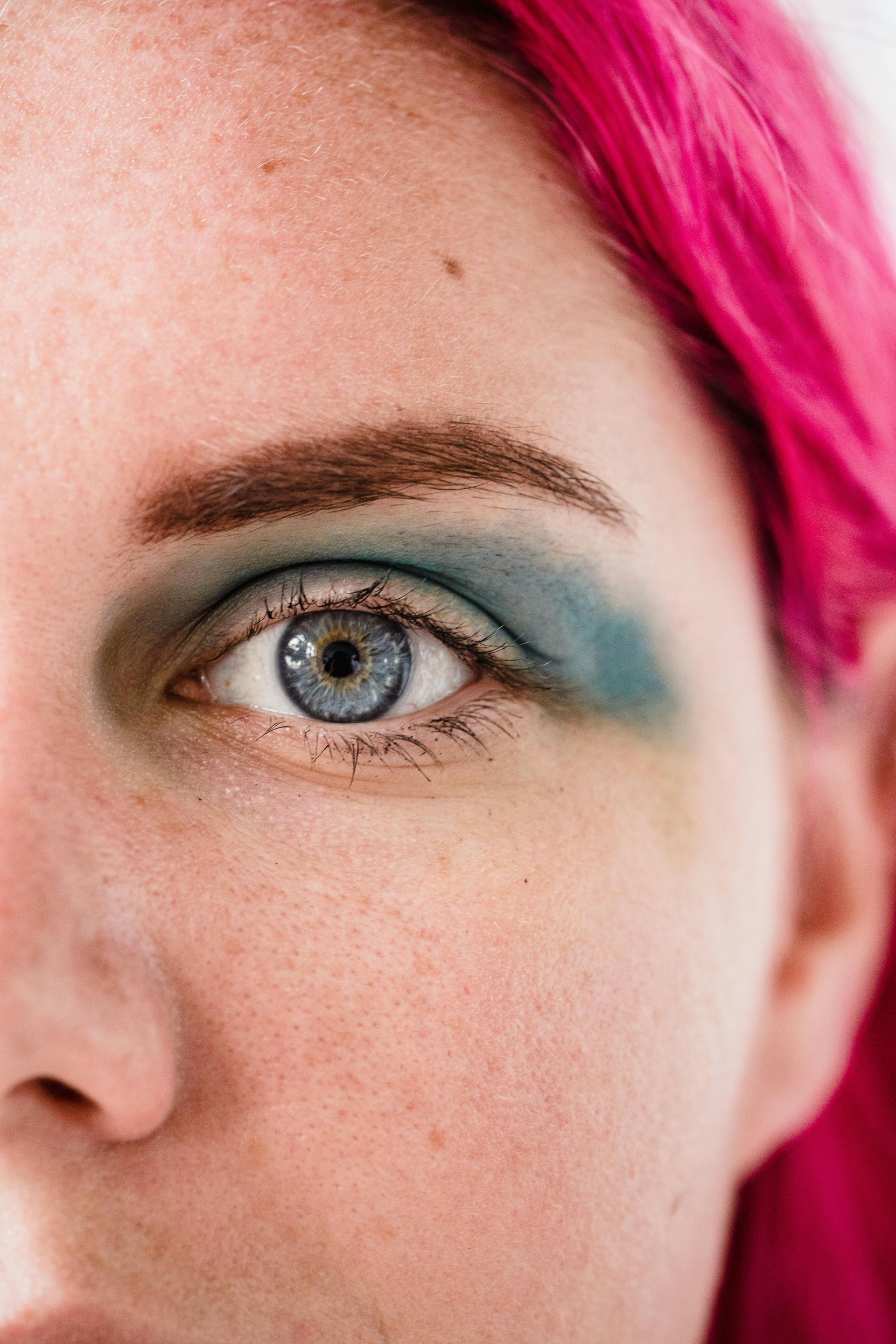 A close up of a woman 's eye with blue eyeshadow.