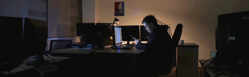 Tech worker in a dark office symbolising the “always on” culture in APAC’s tech sector.