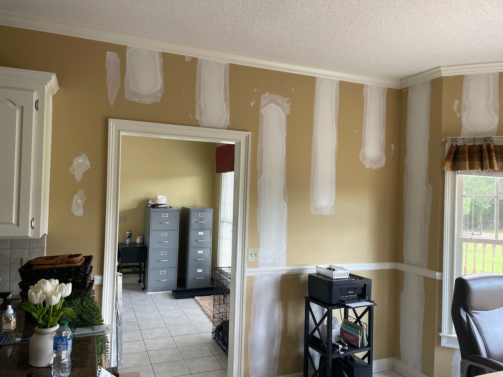 A room with yellow walls and white trim is being remodeled.