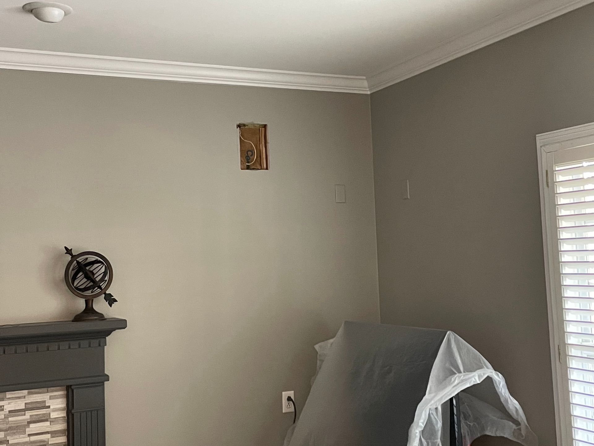A living room with a fireplace and a globe on the mantle.