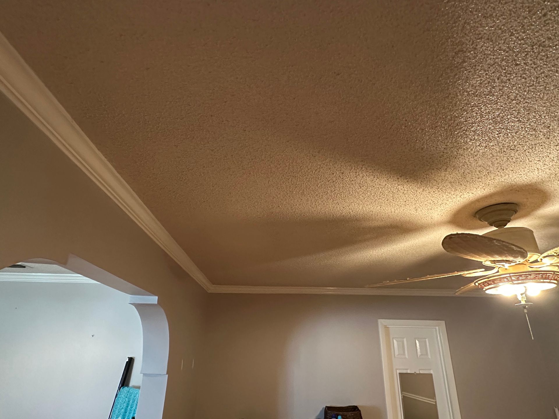 A ceiling fan is hanging from the ceiling of a living room.