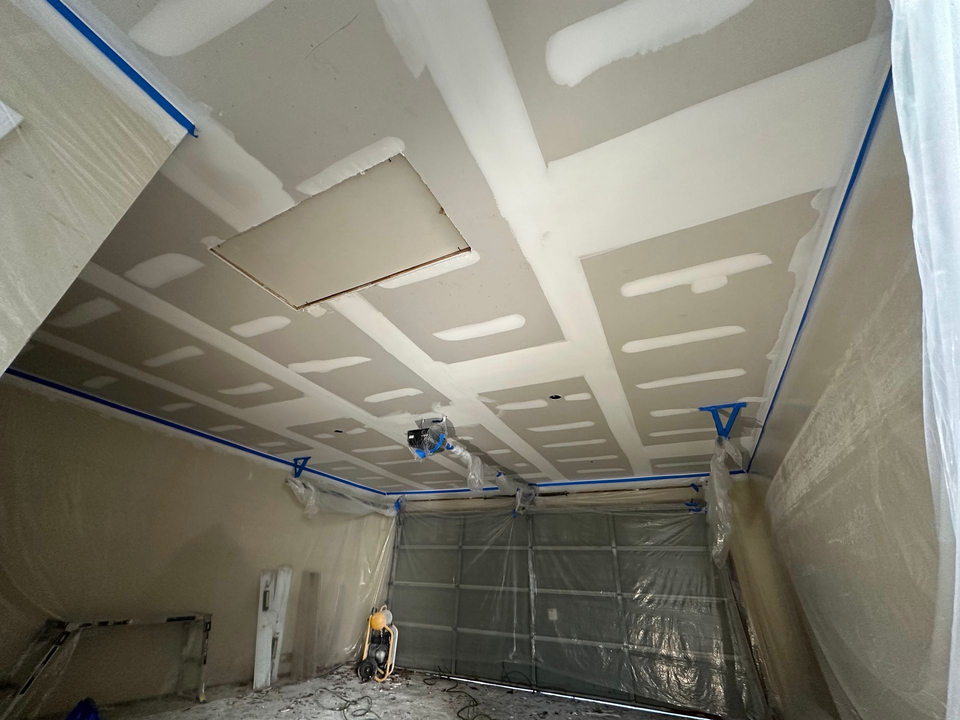 A room with a ceiling that is being painted.