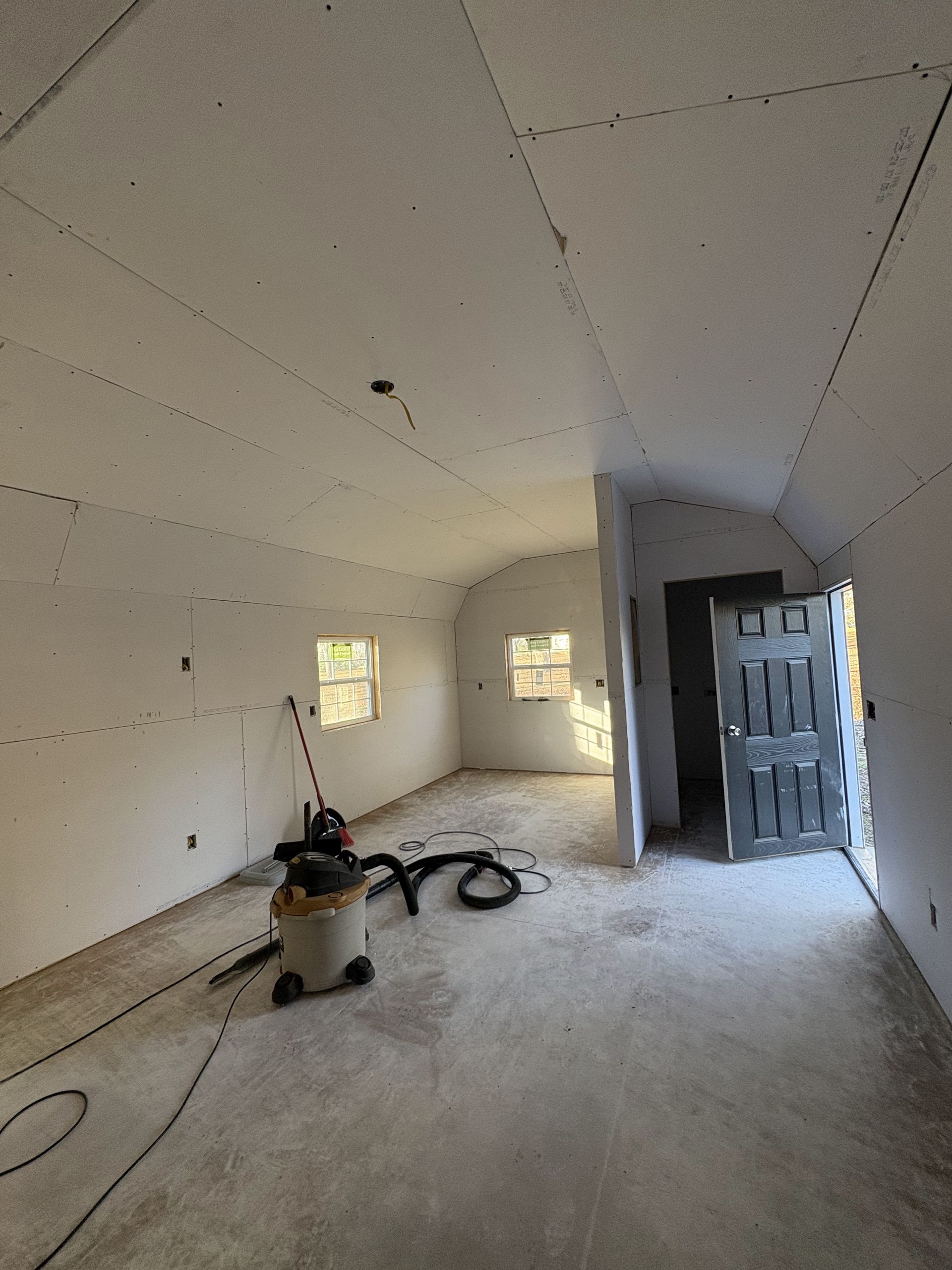 An empty room with a vacuum cleaner on the floor