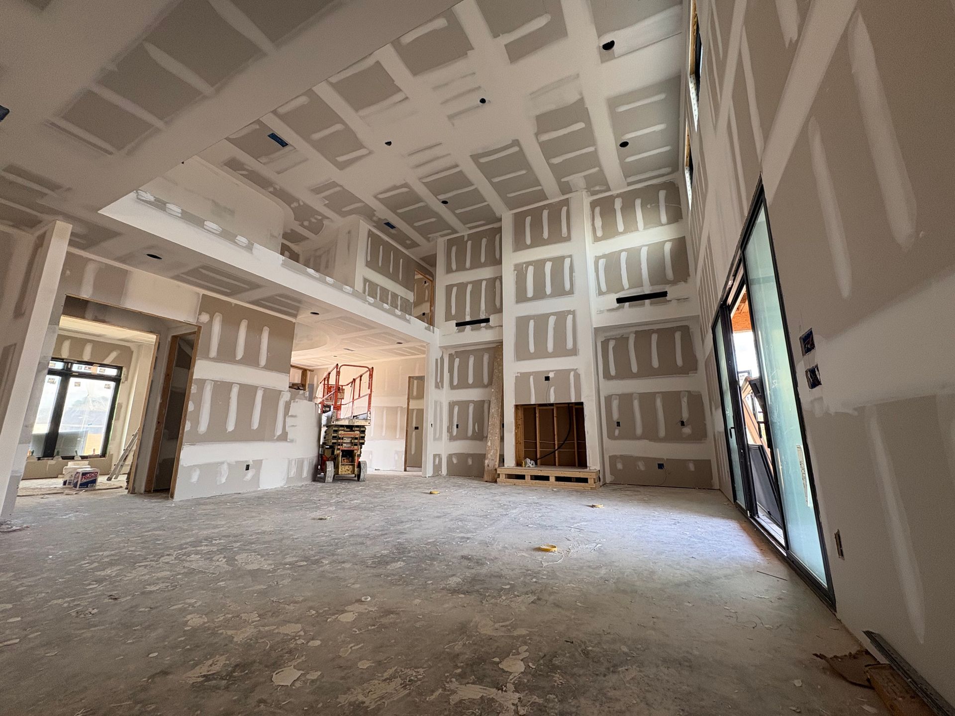 A large empty room with a lot of drywall on the walls and ceiling.