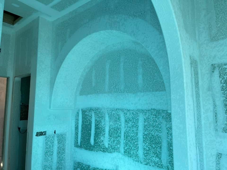A blue and white photo of a room with a large archway.