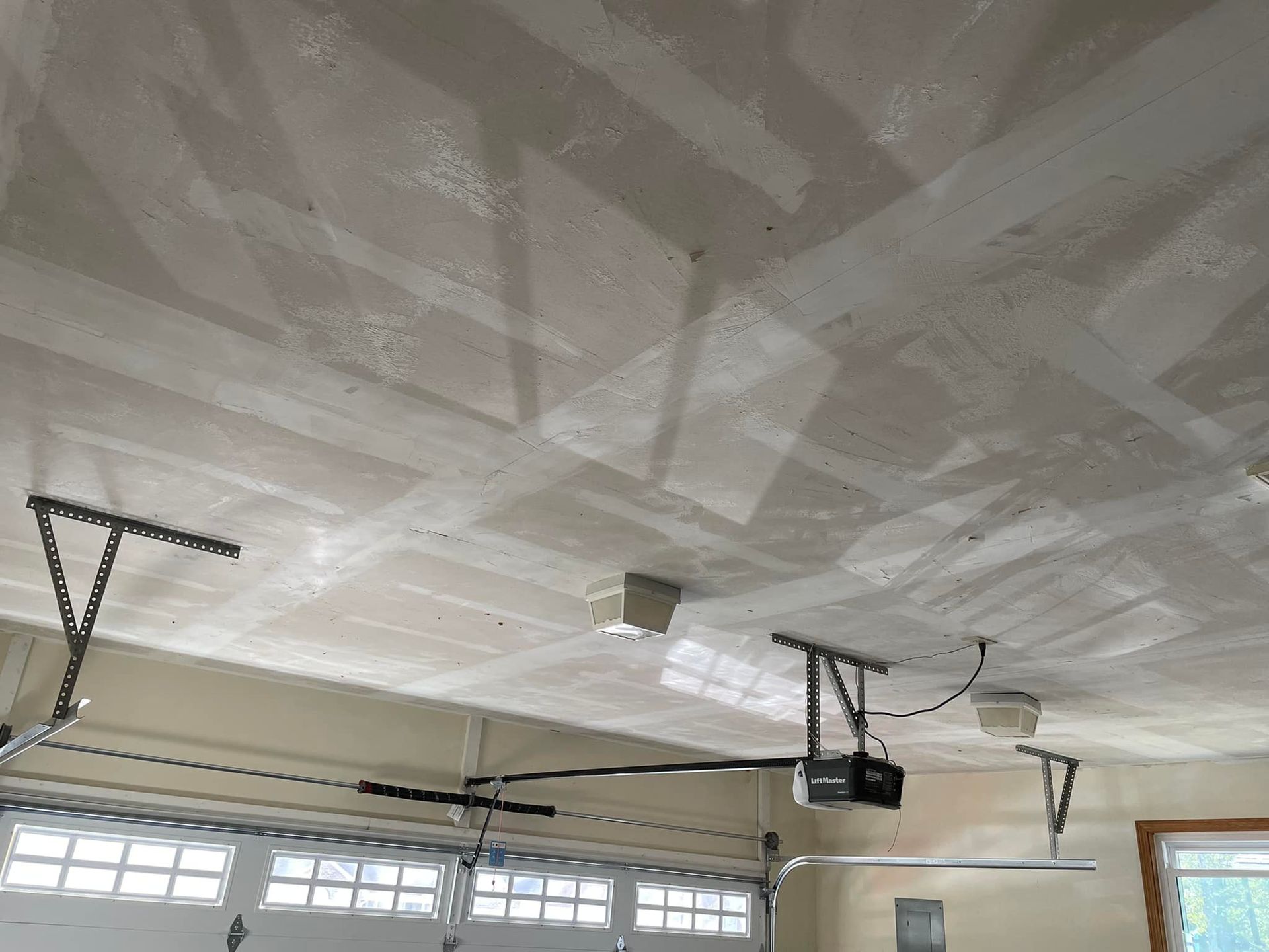 A garage with a ceiling fan and a garage door opener.