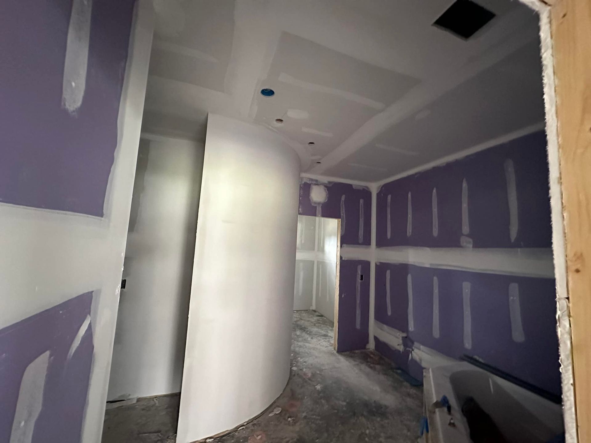 A hallway with purple walls and white walls