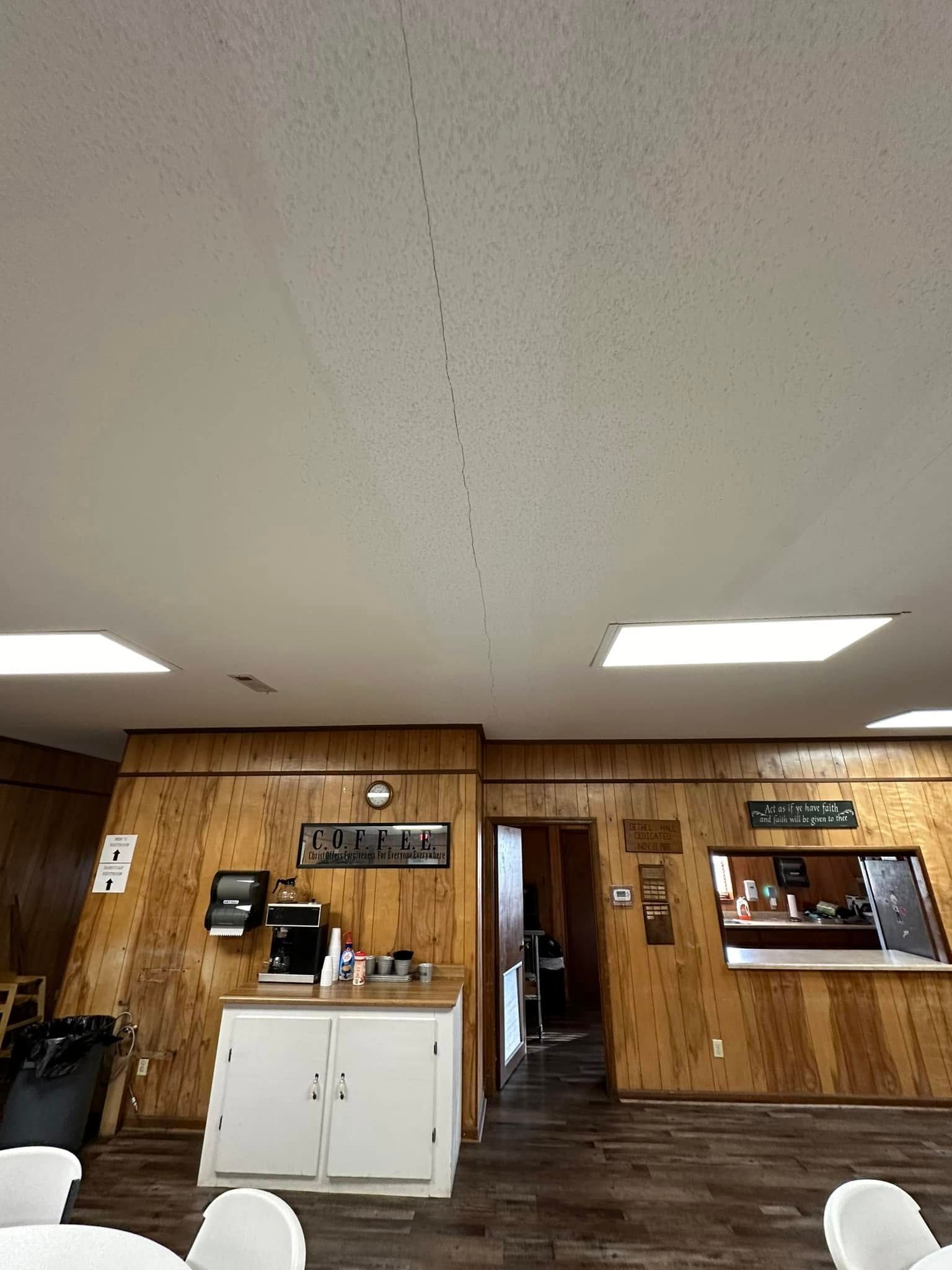 A large room with wooden walls and tables and chairs.