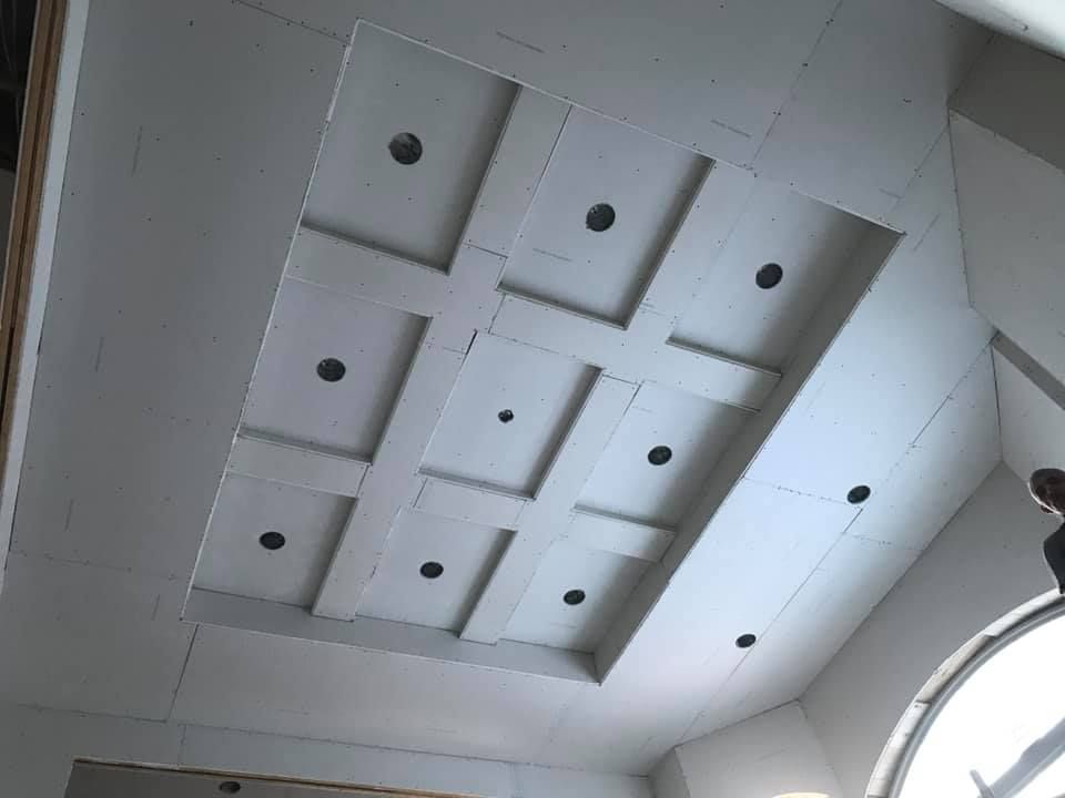 A ceiling with a lot of squares and holes in it.