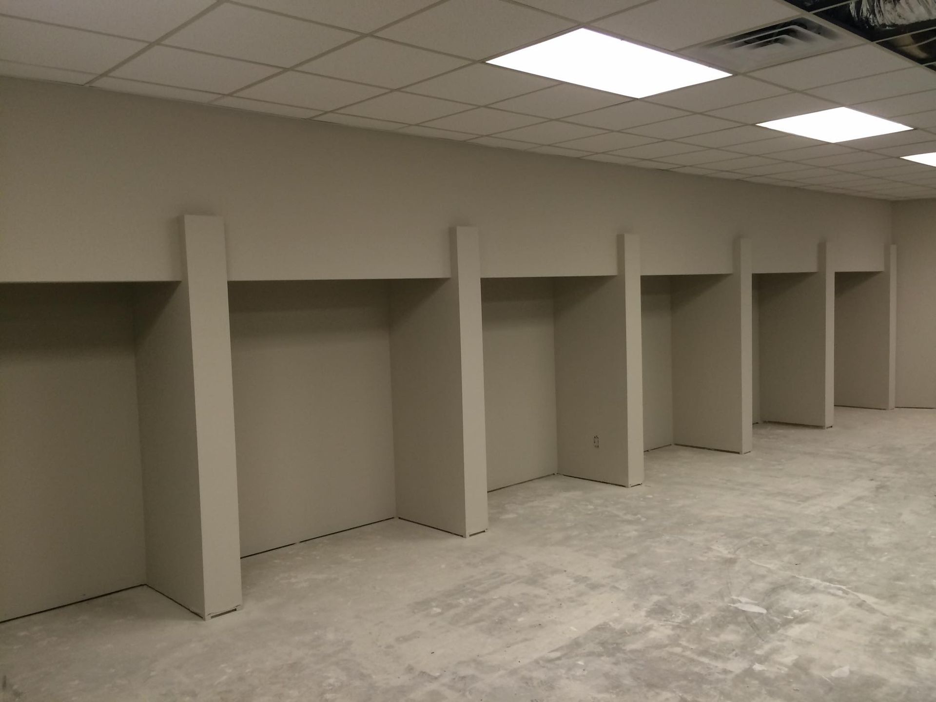 A row of empty cubicles in an empty room
