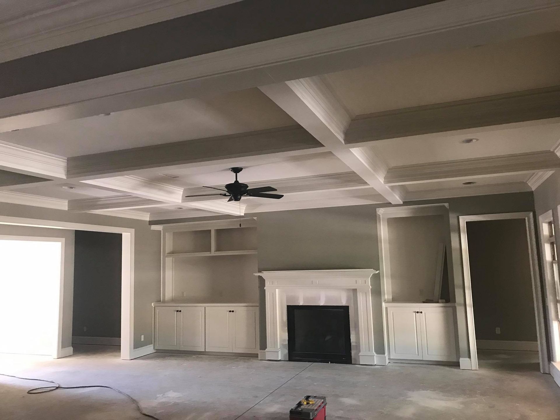 A living room with a fireplace and a ceiling fan