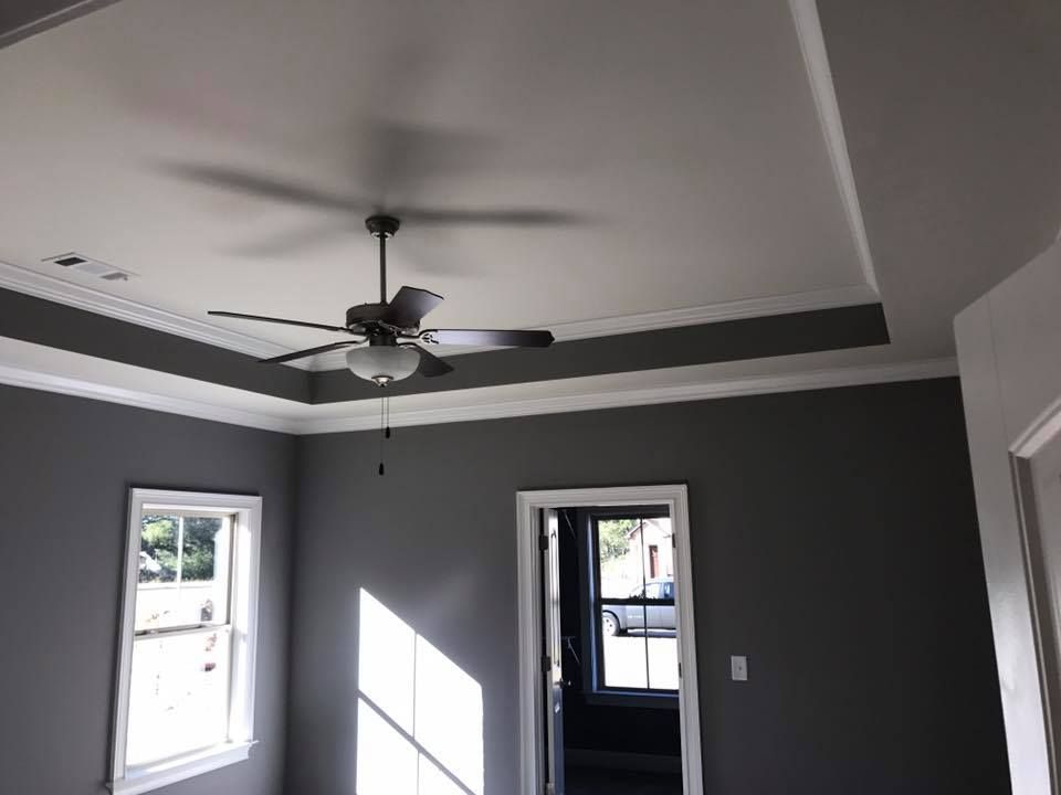 A room with gray walls and a ceiling fan