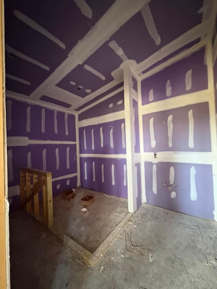 An empty room with purple walls and white trim