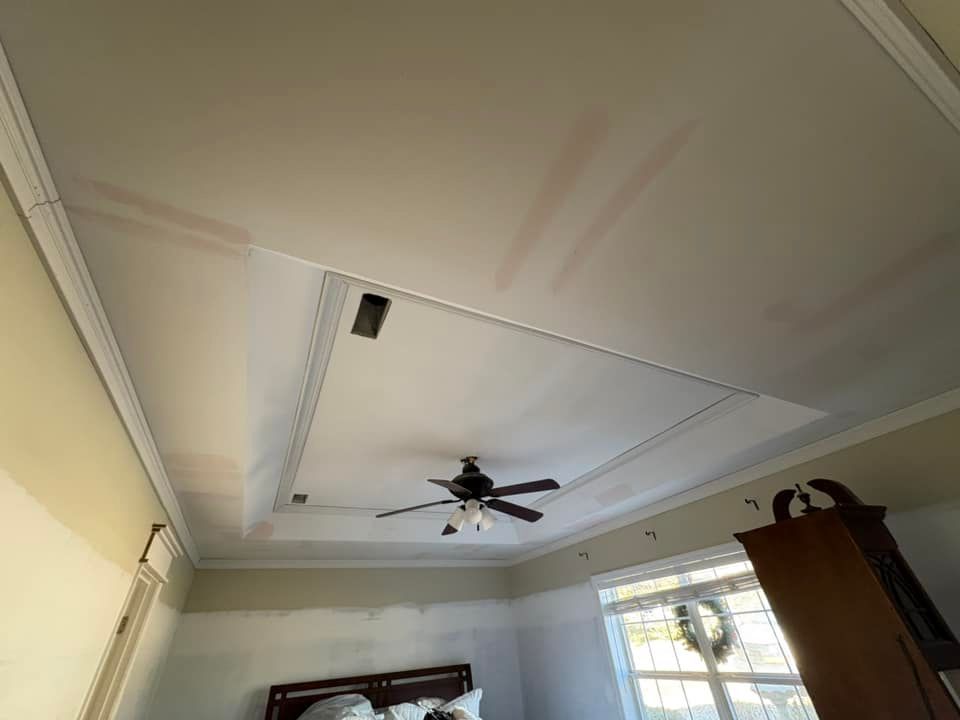 A bedroom with a ceiling fan and a clock on the wall.