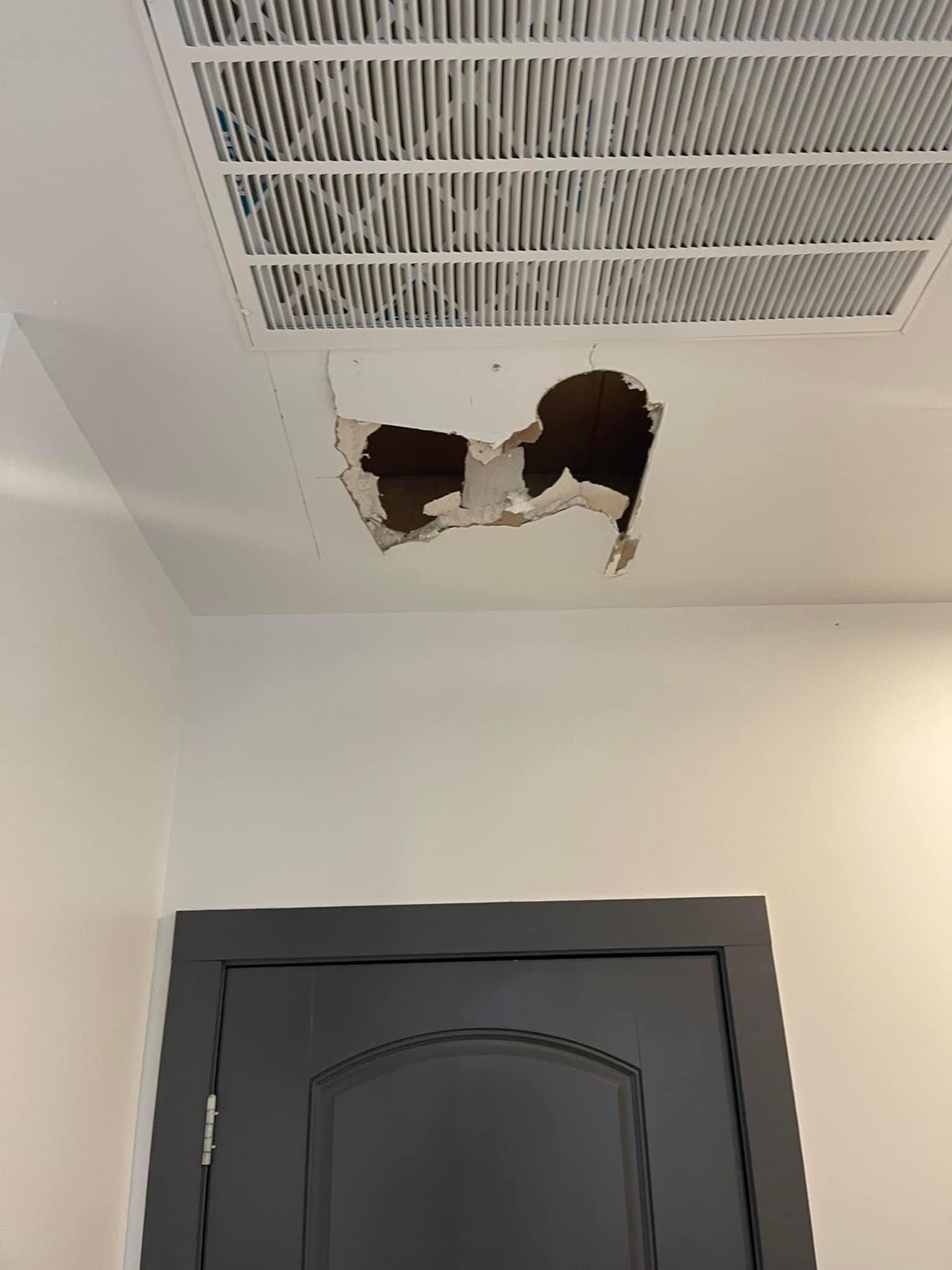 There is a hole in the ceiling above the door.