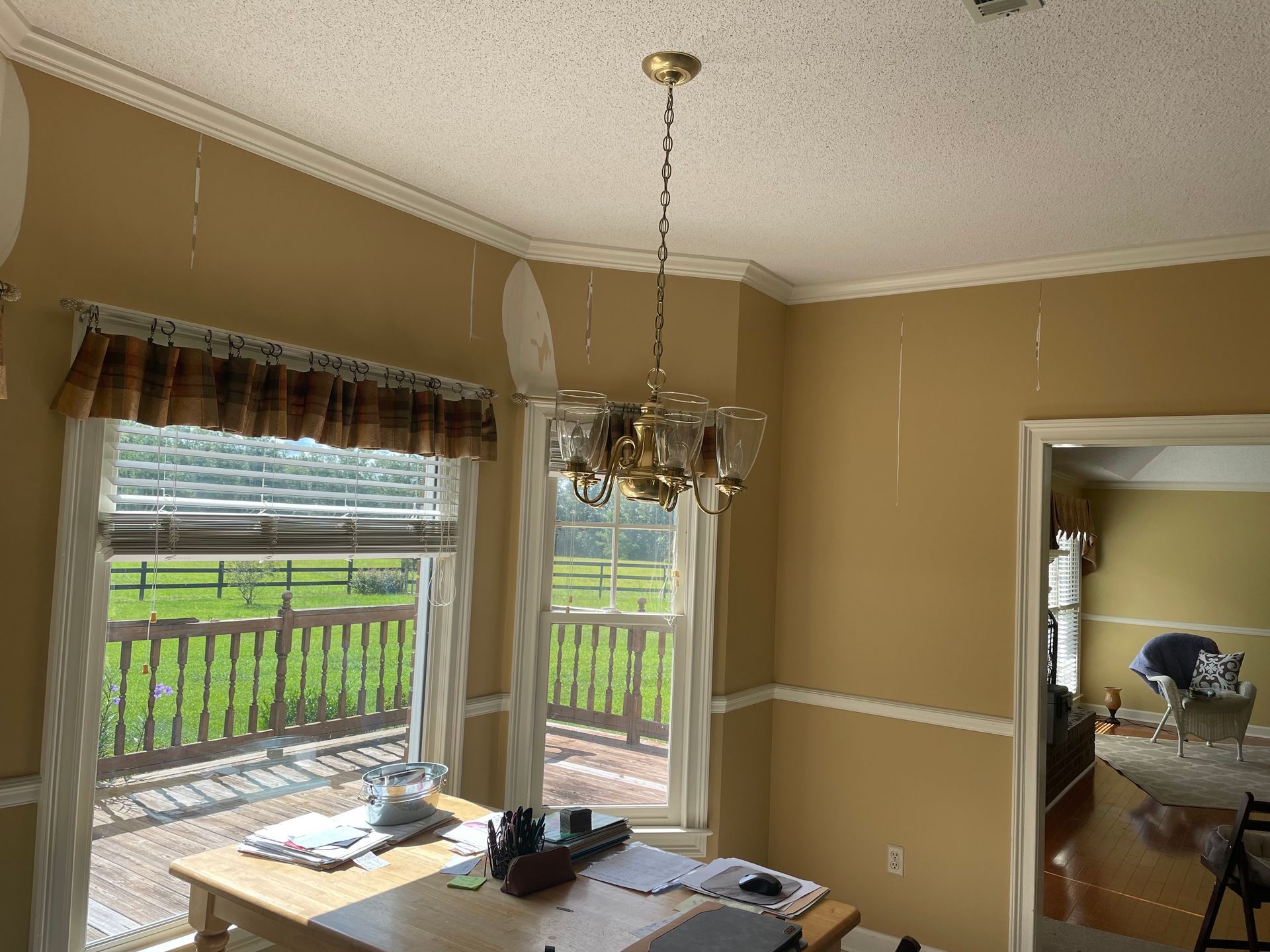 A dining room with a table and a chandelier hanging from the ceiling