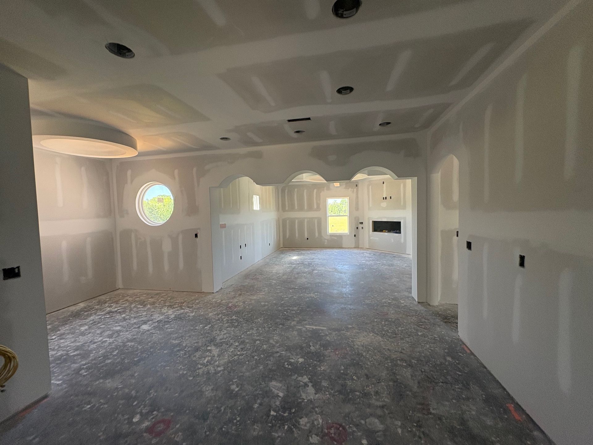 A room that is being remodeled with drywall on the walls and ceiling.