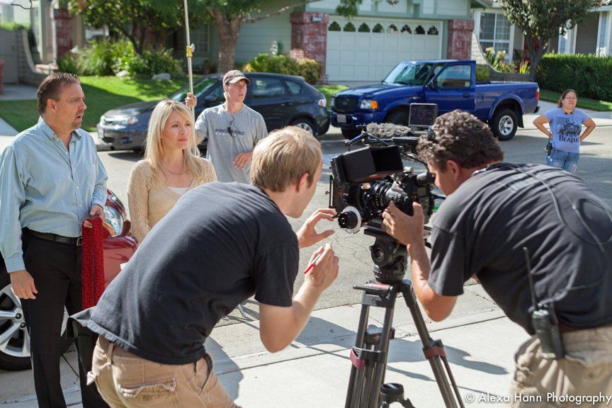 a behind the scenes look with actors and crew setting up for a shot